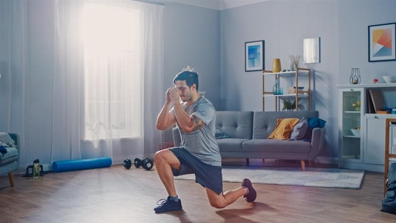 man doing lunges in his bedroom