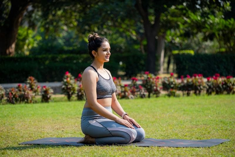 woman doing vajrasana yoga pose